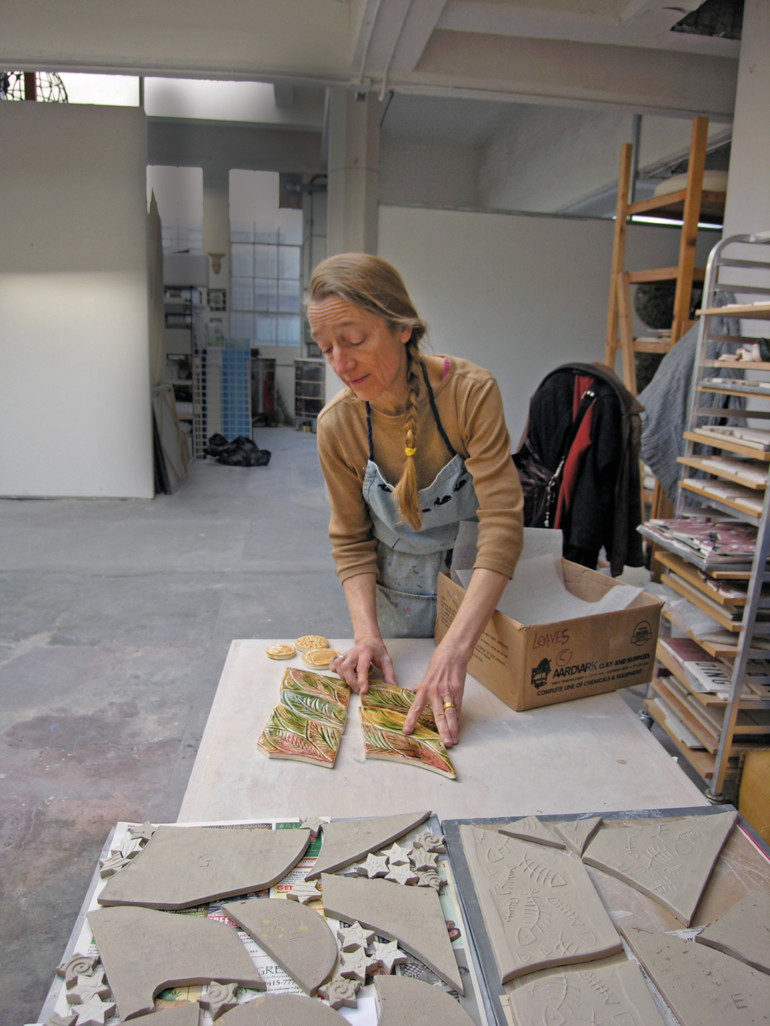 Artist Colette Crutcher unpacks finished leafshaped tiles for a mosaic mural.