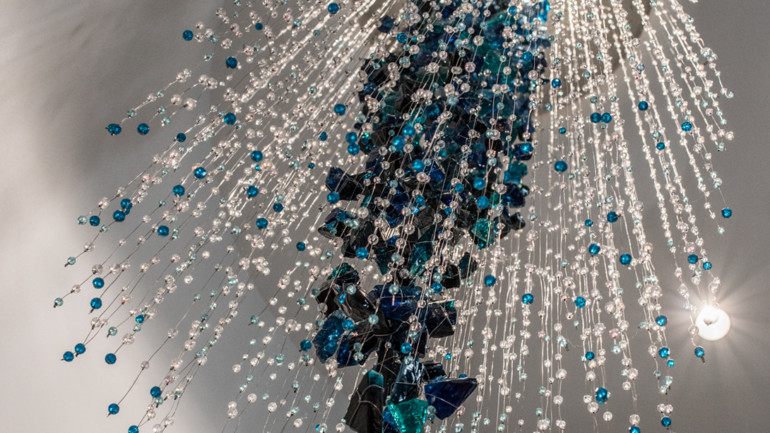 Daniel Goldstein’s “Diver” waterfall of crystals is top lit.