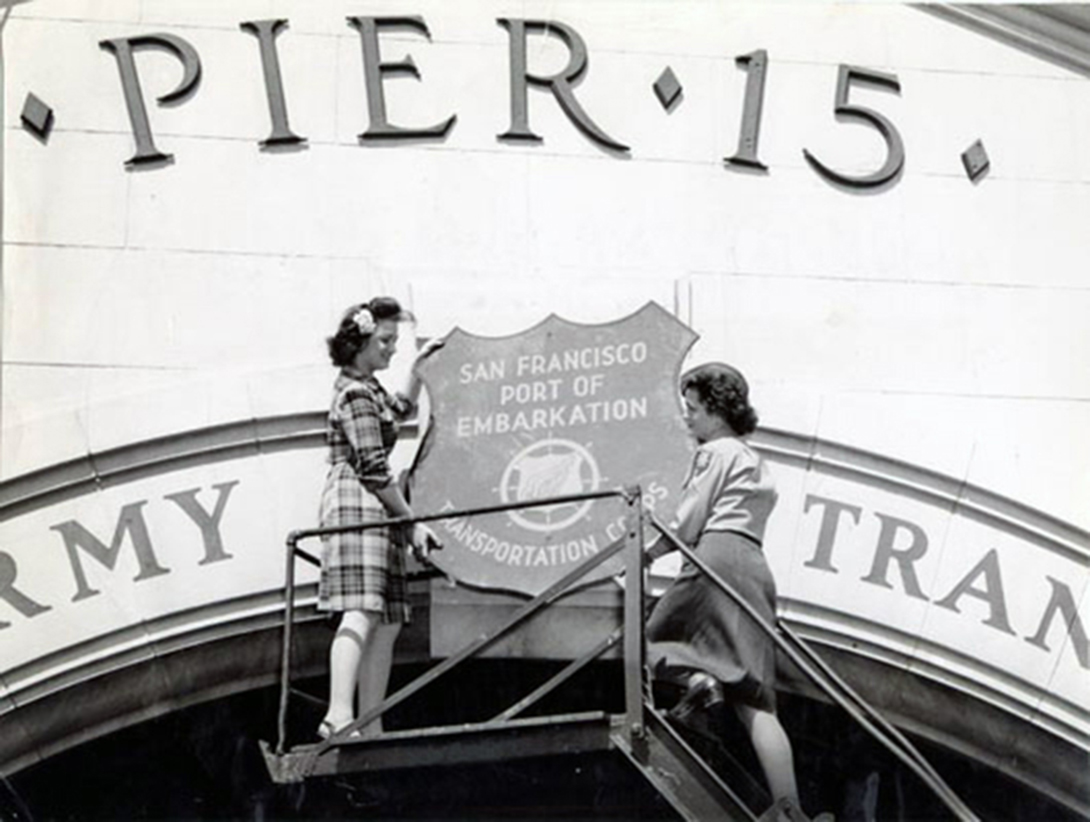 Bonita Pittack and Ruth Butler take the Port of Embarkation shield off of Pier 15 in 1946