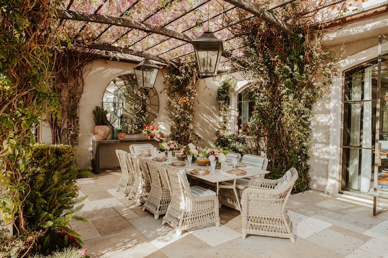The outdoor dining area comprises a table and chairs from Janus et Cie. The seat cushions are upholstered in outdoor fabric from F. Schumacher.