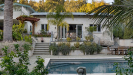 Exterior of the Calders’ ADU in Fairfax, with stairs leading to the patio, surrounded by greenery and overlooking a backyard swimming pool.