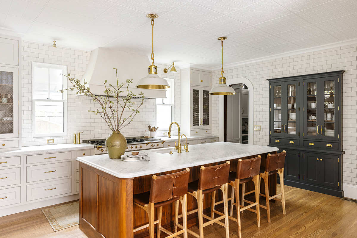A modern kitchen featuring white cabinets and warm wooden floors, creating a bright and inviting atmosphere.