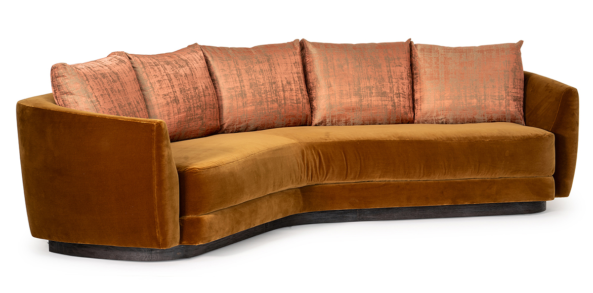 Curved couch featuring a warm brown and orange color scheme, adding a cozy touch to the living space.