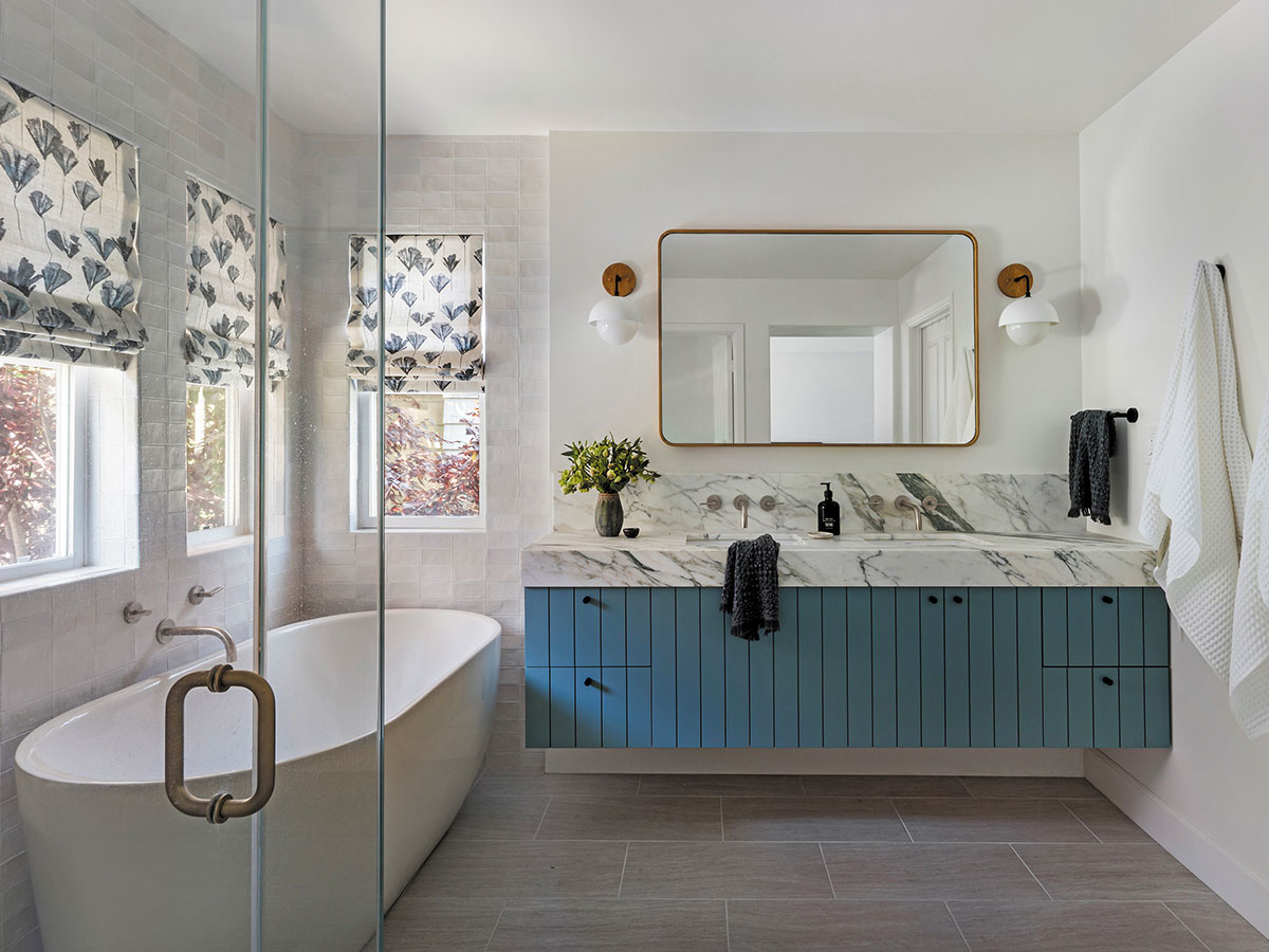 A bathroom featuring blue cabinets and a white bathtub, creating a modern and inviting atmosphere.