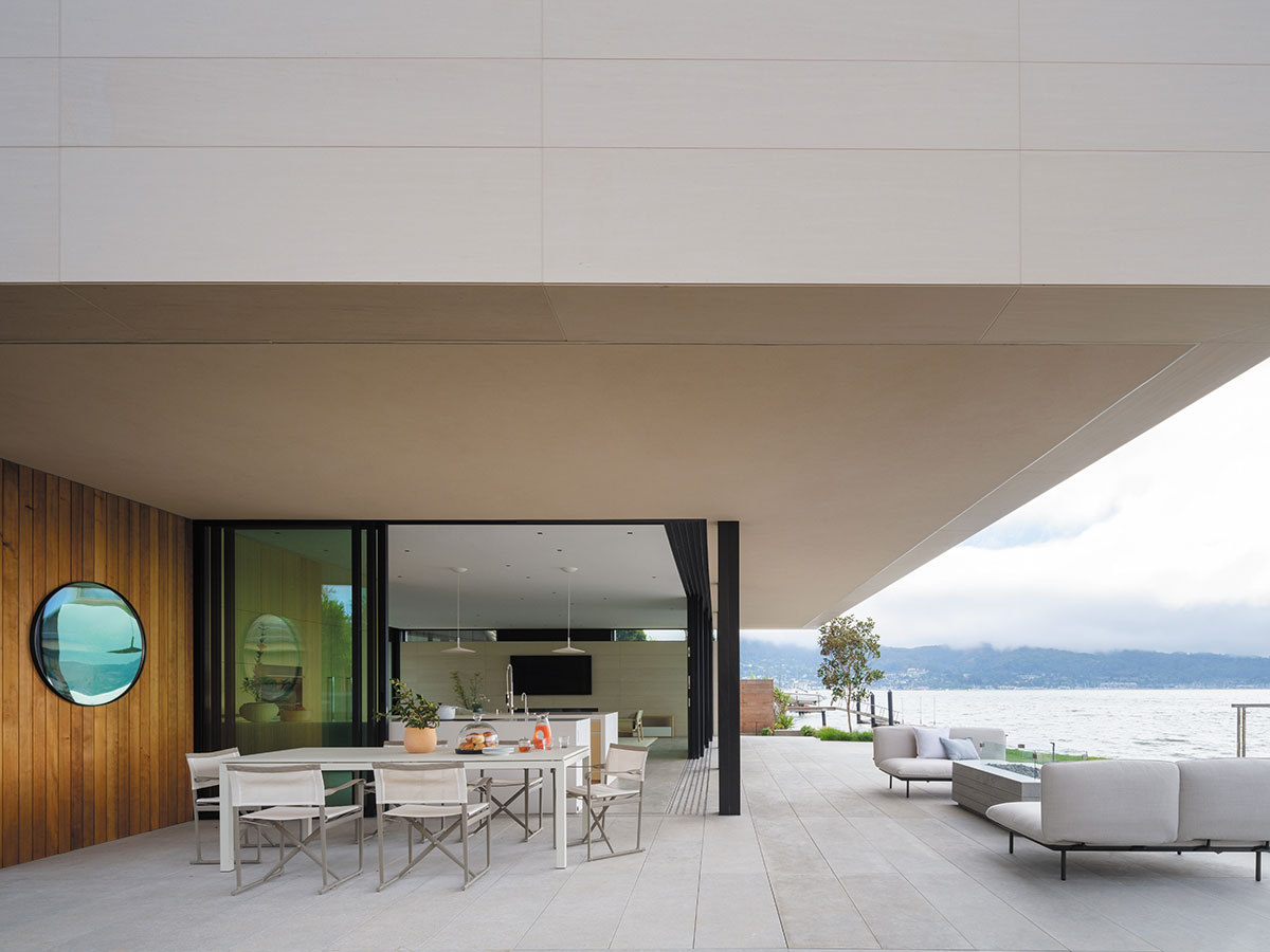 A patio featuring a table and chairs with a scenic view of the water in the background