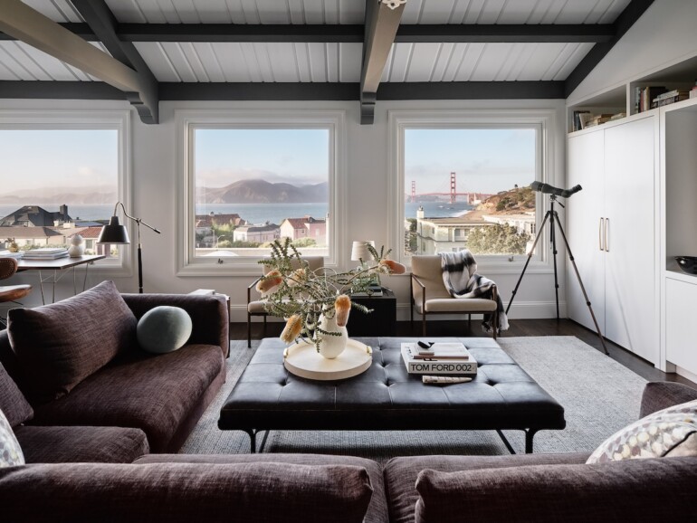 A cozy living room featuring large windows that showcase a scenic view of the bay.