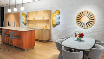 A cozy kitchen scene with a dining table and four chairs, complemented by cabinets and kitchen appliances.