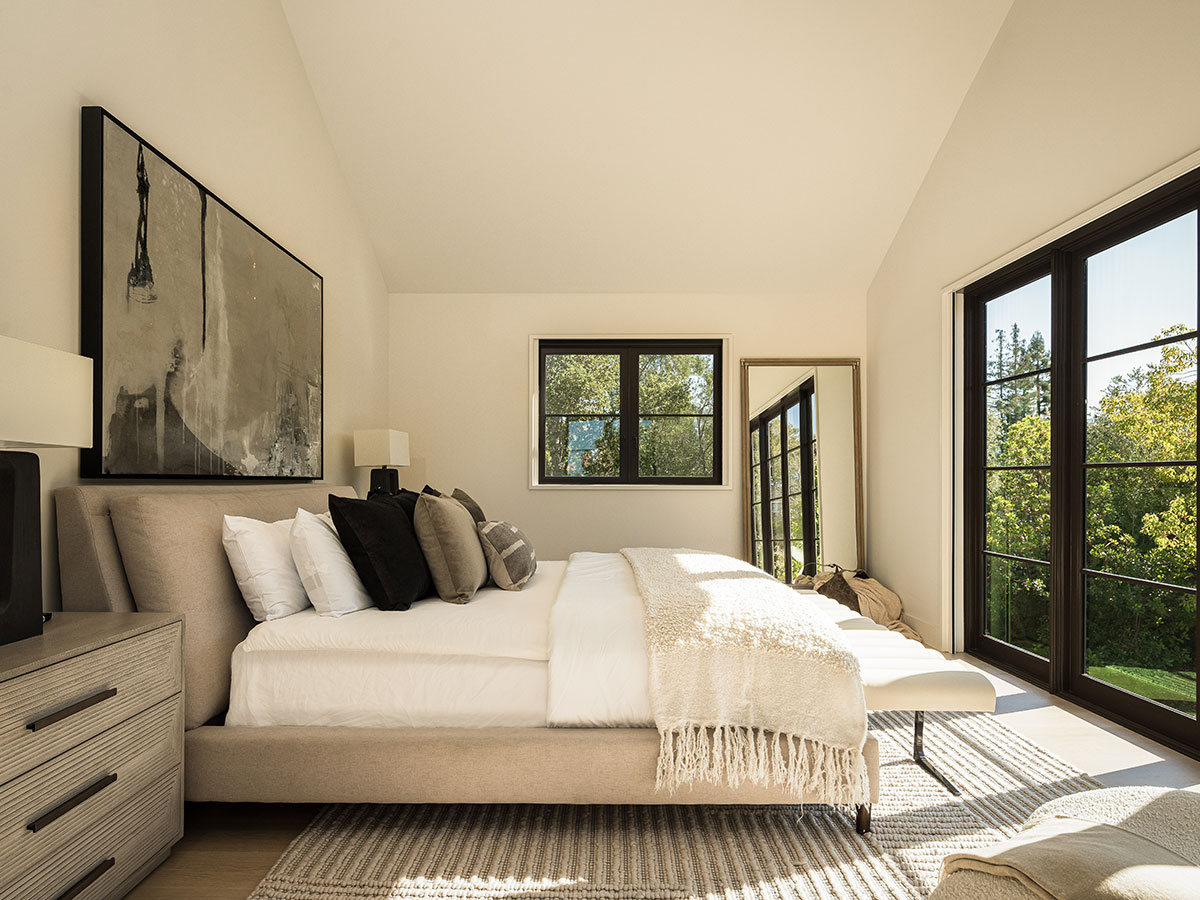 A vaulted ceiling and natural light contribute to the primary bedroom’s airy feel