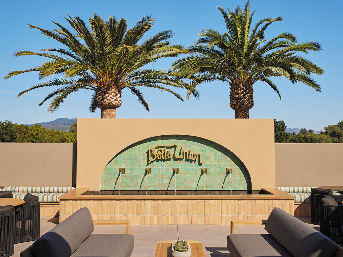 A patio featuring a decorative fountain surrounded by several comfortable couches for relaxation.