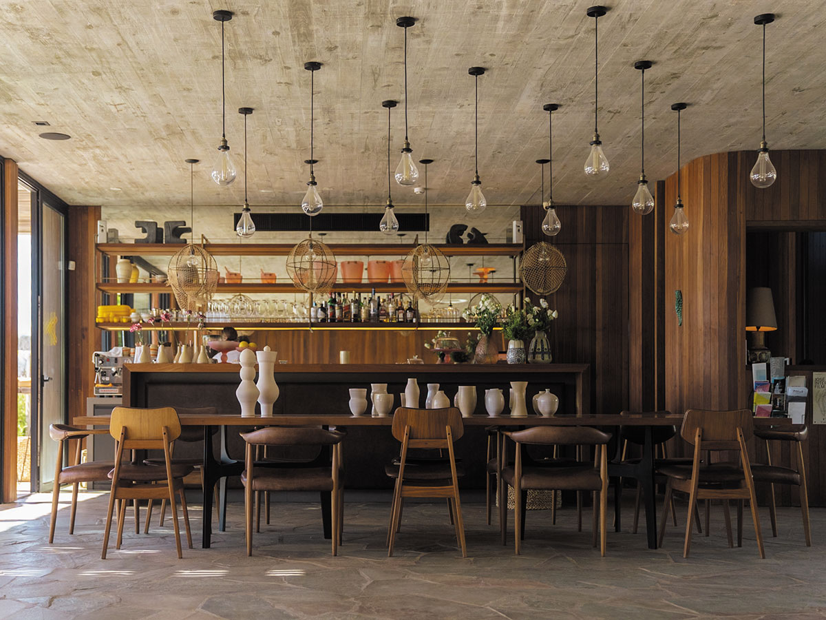 Interior of a restaurant showcasing rustic wooden tables and chairs for guests.