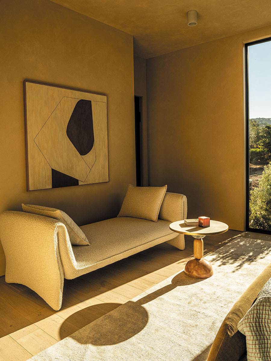 A cozy living room featuring a couch and a large window letting in natural light.