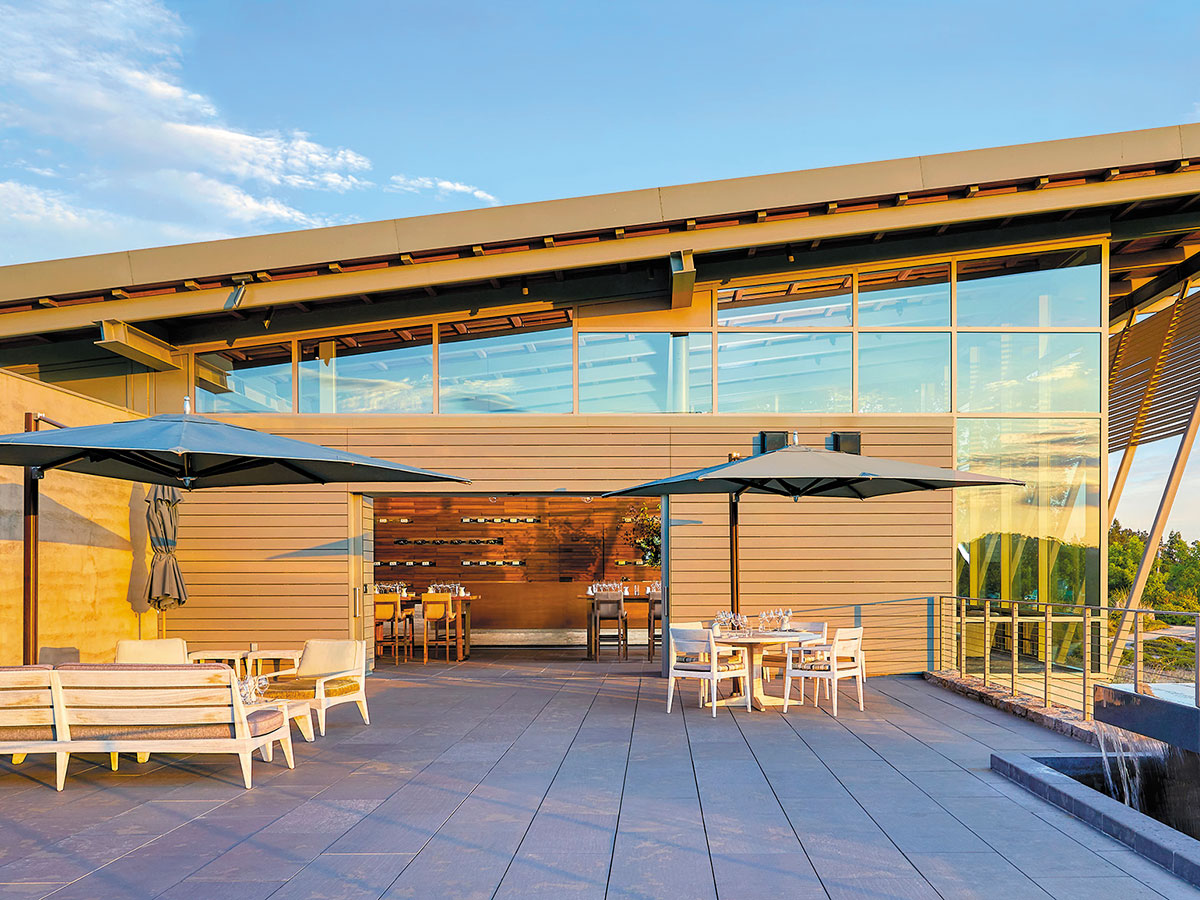 A patio featuring tables and chairs, each shaded by colorful umbrellas, inviting for outdoor dining and relaxation.