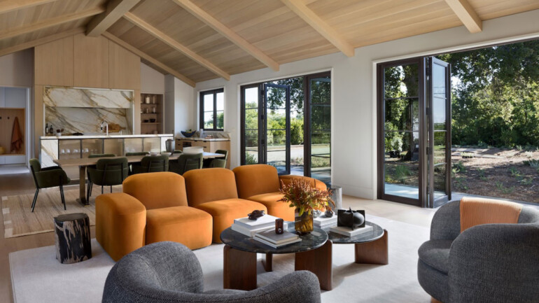 A spacious living room featuring a large wooden ceiling and a comfortable couch, creating a warm and inviting atmosphere.