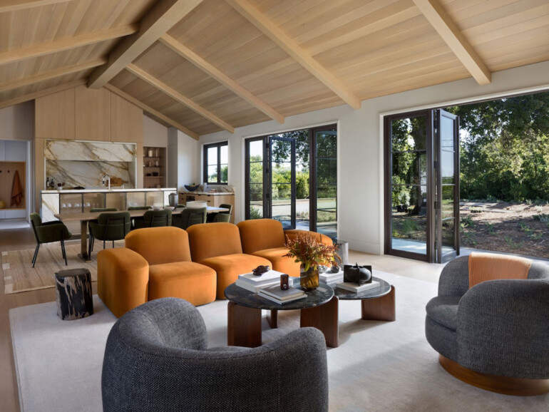 A spacious living room featuring a large wooden ceiling and a comfortable couch, creating a warm and inviting atmosphere.