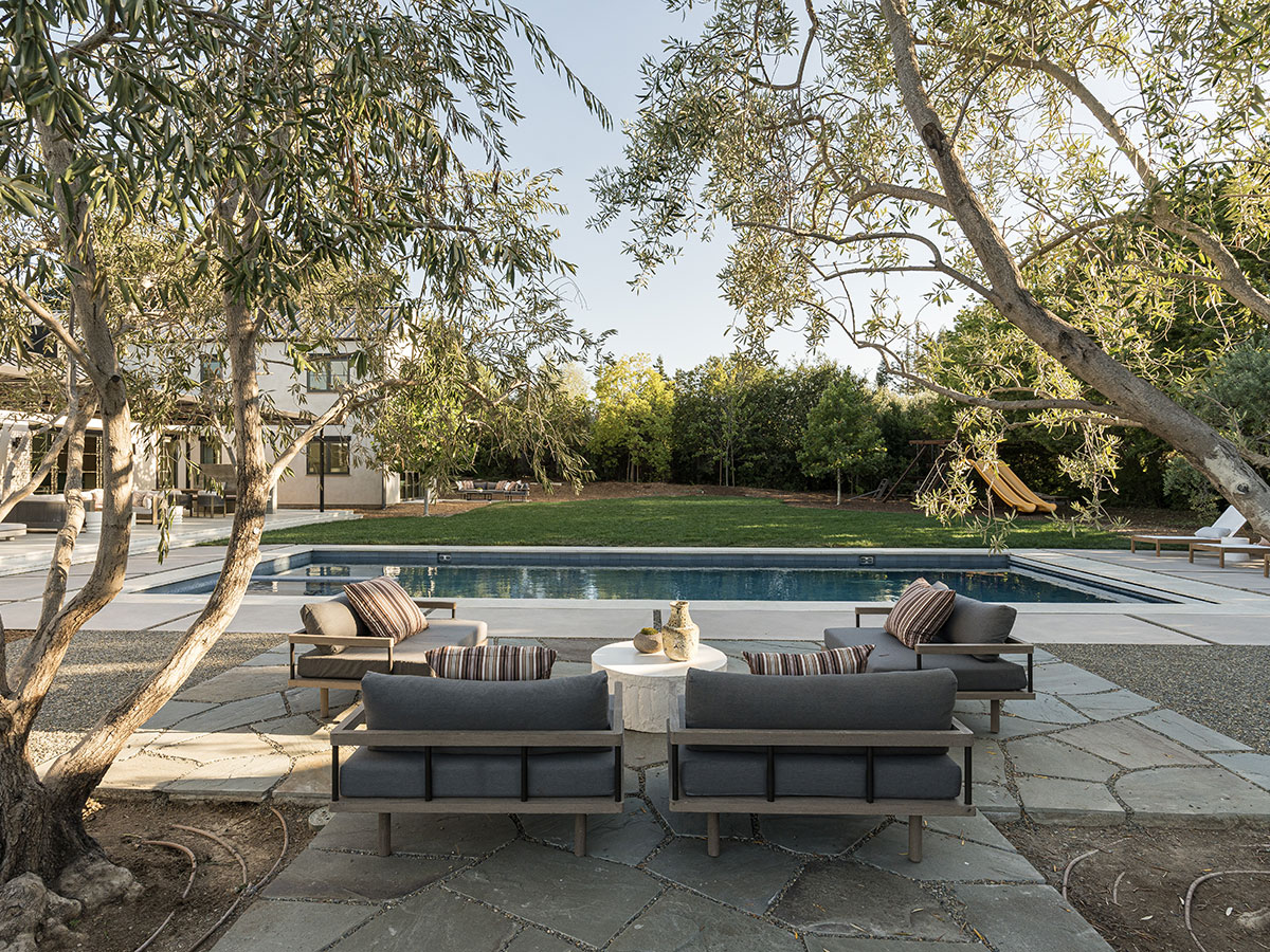 A patio featuring a swimming pool surrounded by outdoor furniture for relaxation and leisure.