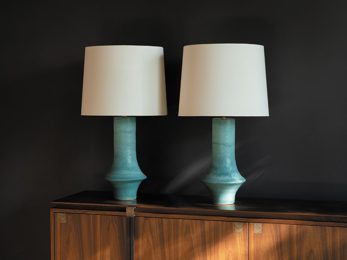 Two blue lamps are placed on a wooden cabinet, creating a stylish and cozy atmosphere in the room.