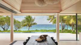 A dining table with chairs, featuring a stunning view of the ocean, creating a tranquil dining atmosphere.