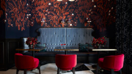 A dining room with vibrant red chairs and a blue bench, creating a colorful and inviting atmosphere.