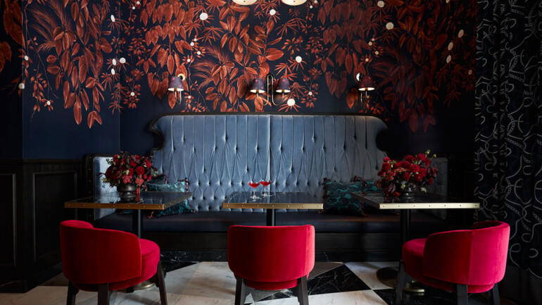 A dining room with vibrant red chairs and a blue bench, creating a colorful and inviting atmosphere.