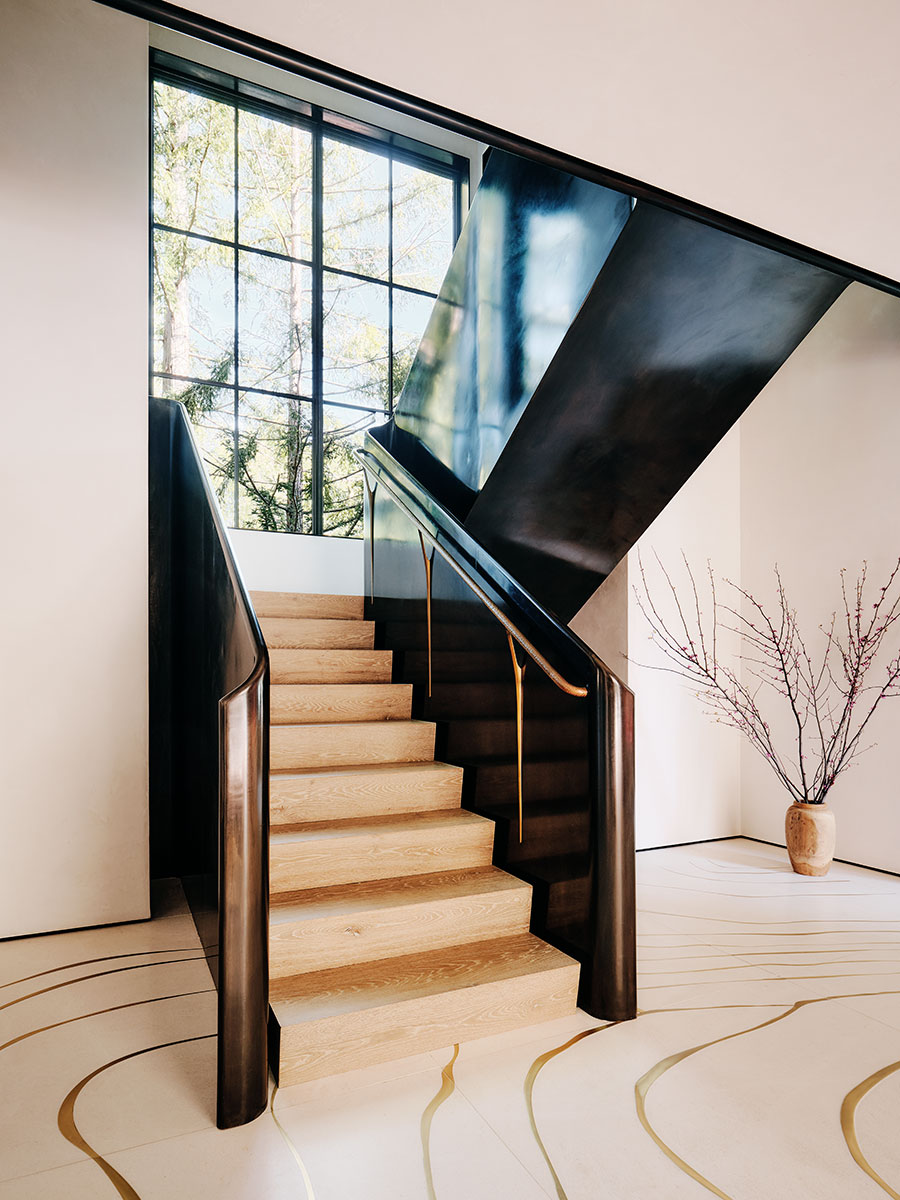 A stylish staircase with black railings and gold accents, highlighting a sophisticated architectural detail.