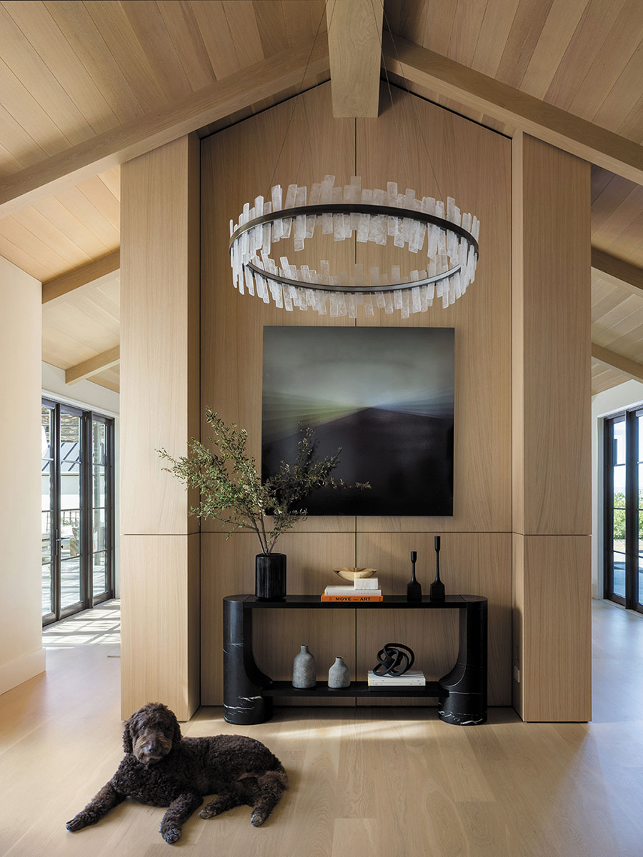 Illuminated by a chandelier from Coup D’Etat, the entryway features a CB2 console that was customized to fit the space and art by Bernadette Jiyong Frank