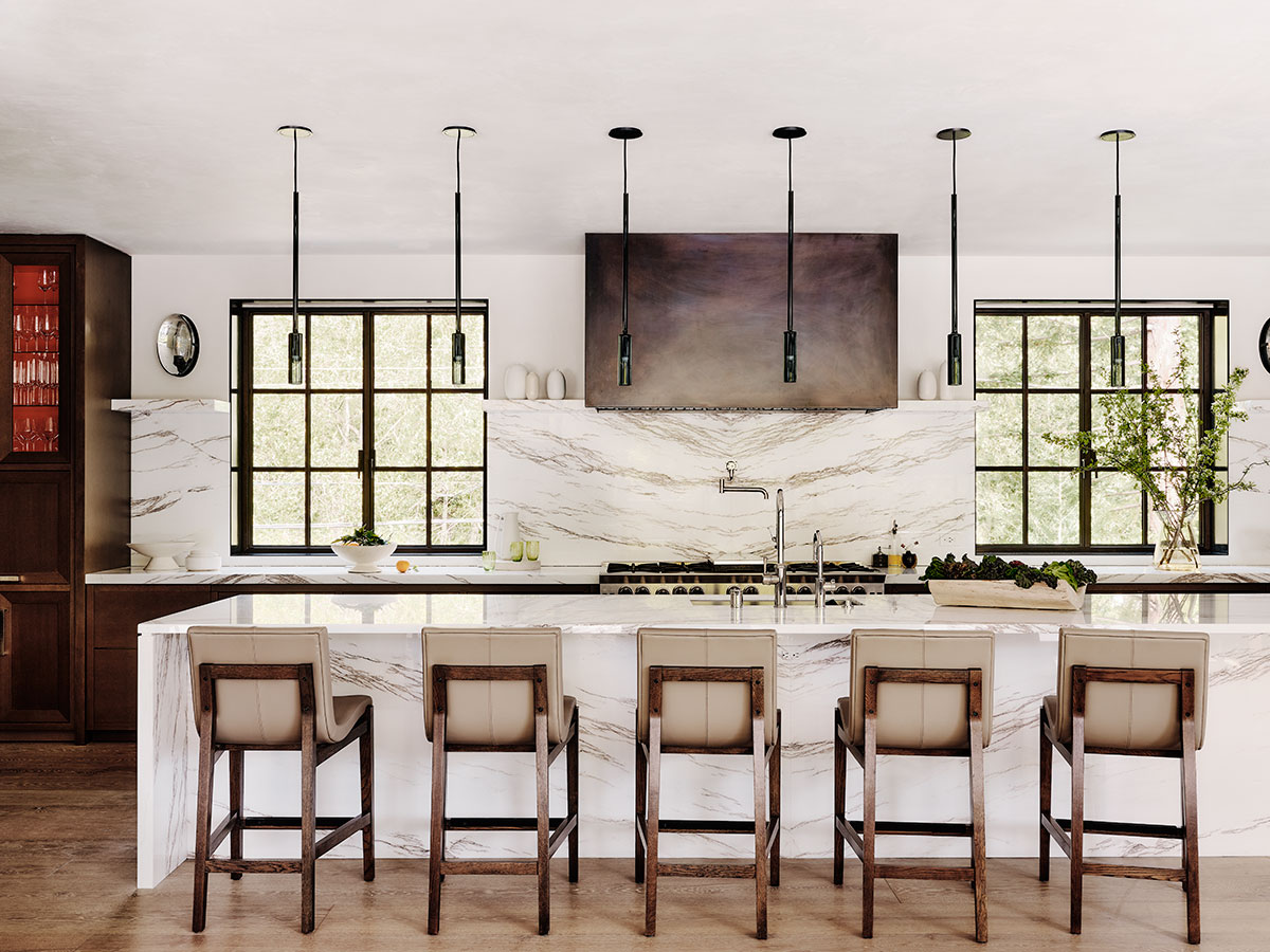 A modern kitchen featuring elegant marble countertops and warm wooden cabinets.
