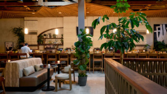 A restaurant interior featuring a bar and several dining tables arranged for guests.