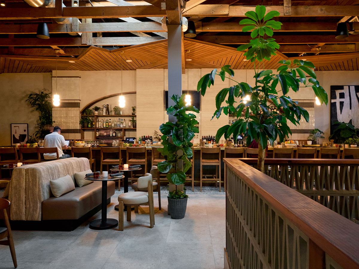 A restaurant interior featuring a bar and several dining tables arranged for guests.