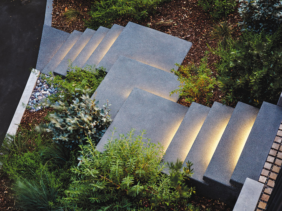A concrete staircase illuminated by lights, creating a warm and inviting atmosphere