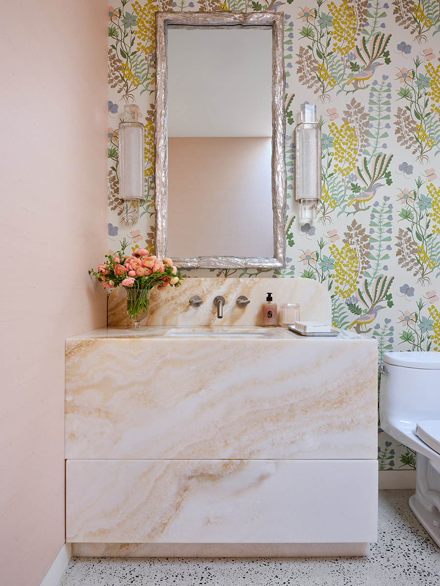 Elegant bathroom with floral wallpaper, a marble vanity, and a large mirror.